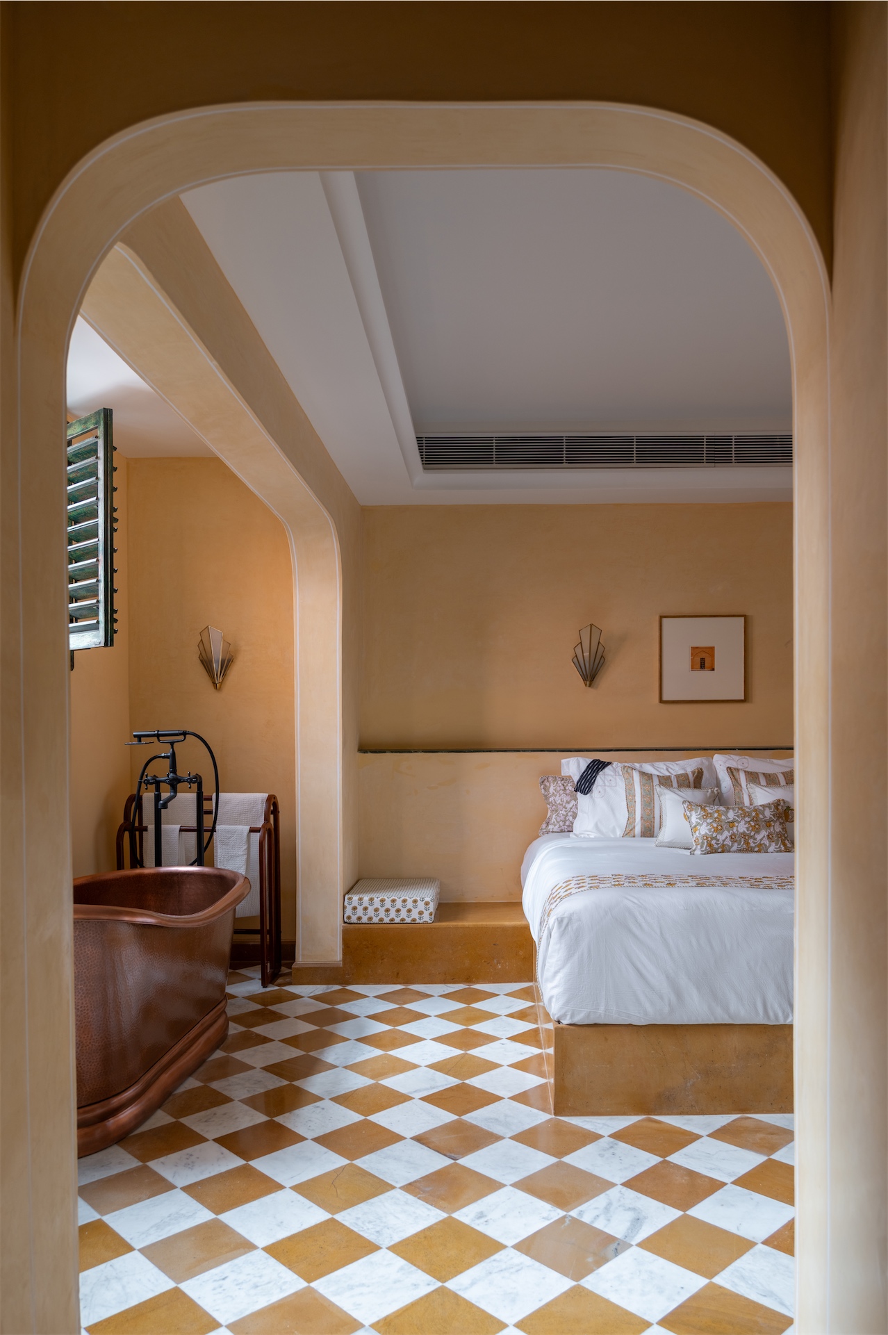 Suite at Abode Jaipur with freestanding copper bathtub and patterned tile flooring.