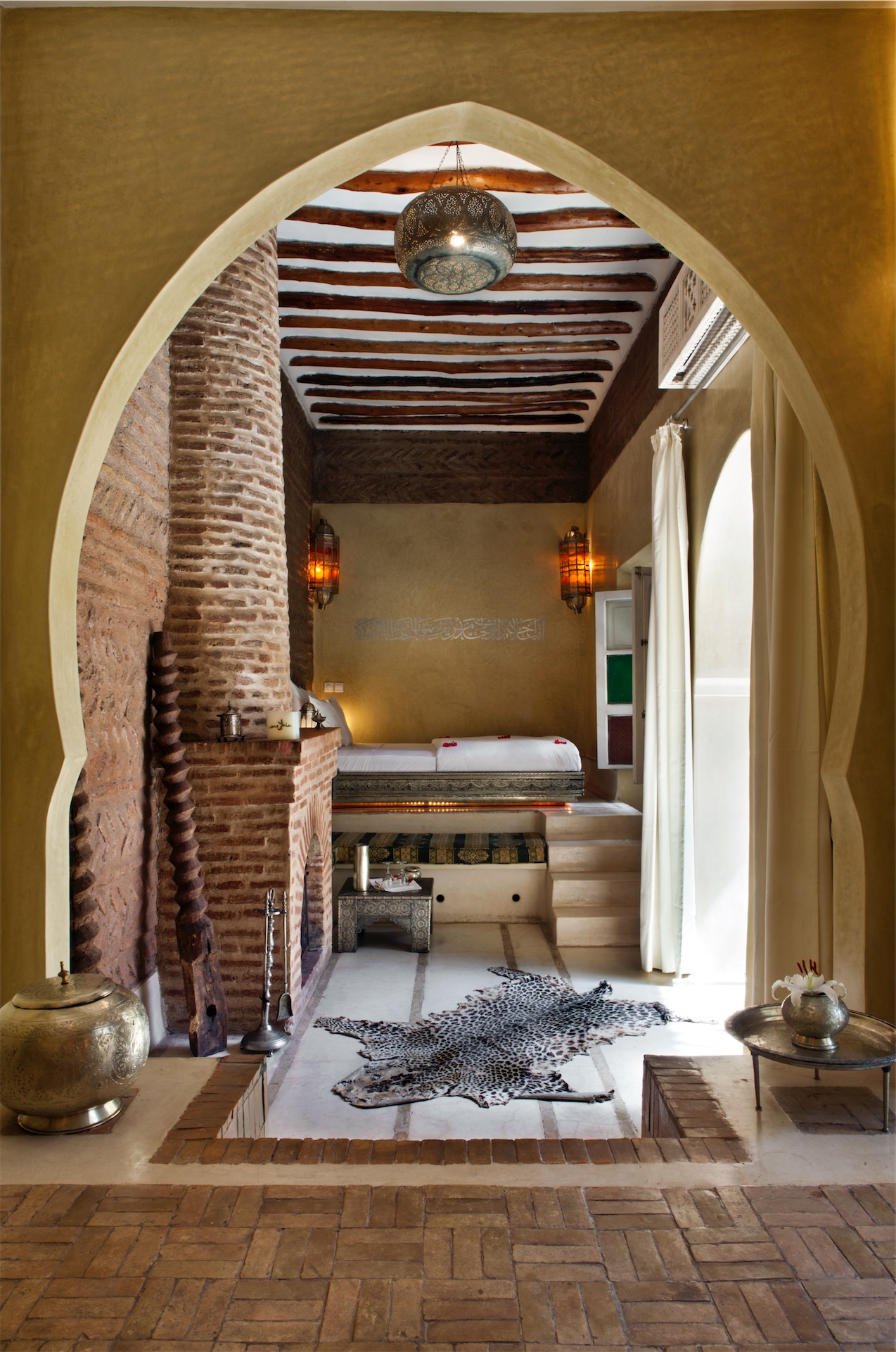 Suite interior with arched entry, brick detail, and lantern lighting at Anayela.