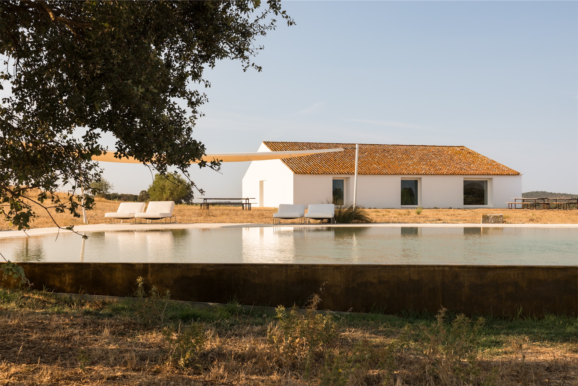 Exterior view of Casa No Tempo with swimming pool and whitewashed buildings in the landscape.