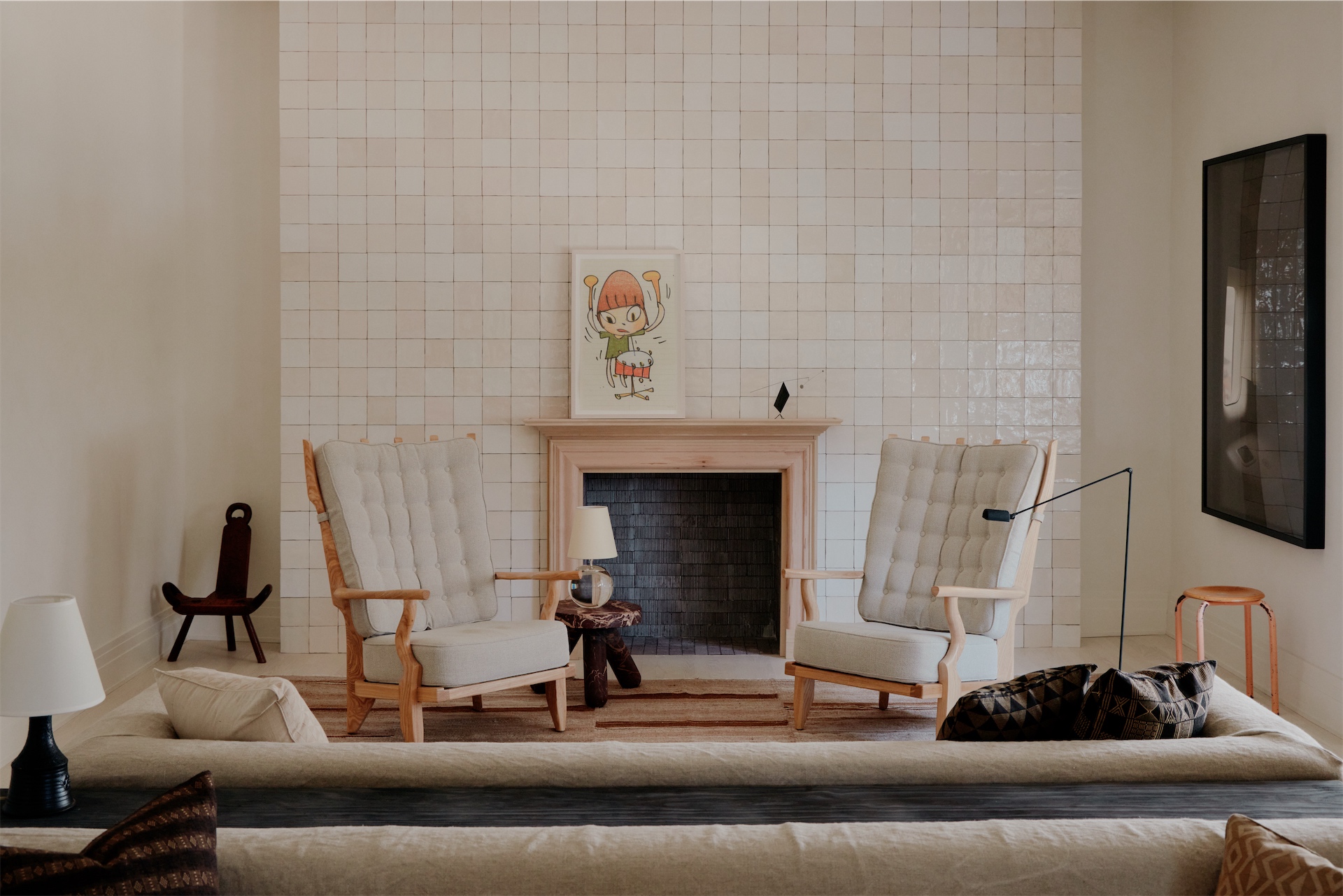 Lobby seating area with tiled fireplace and upholstered chairs at The James Bradley.