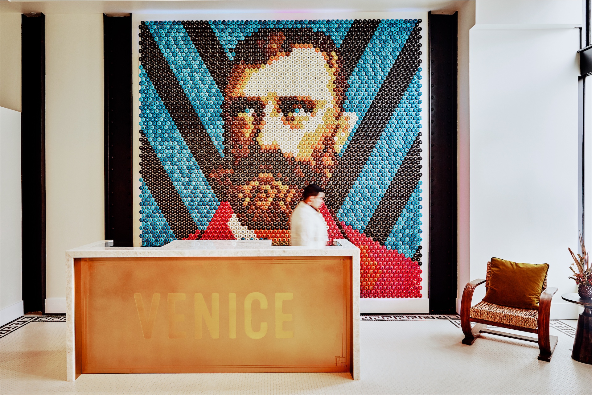 Reception desk with large pop-art mural behind it at Venice V Hotel.