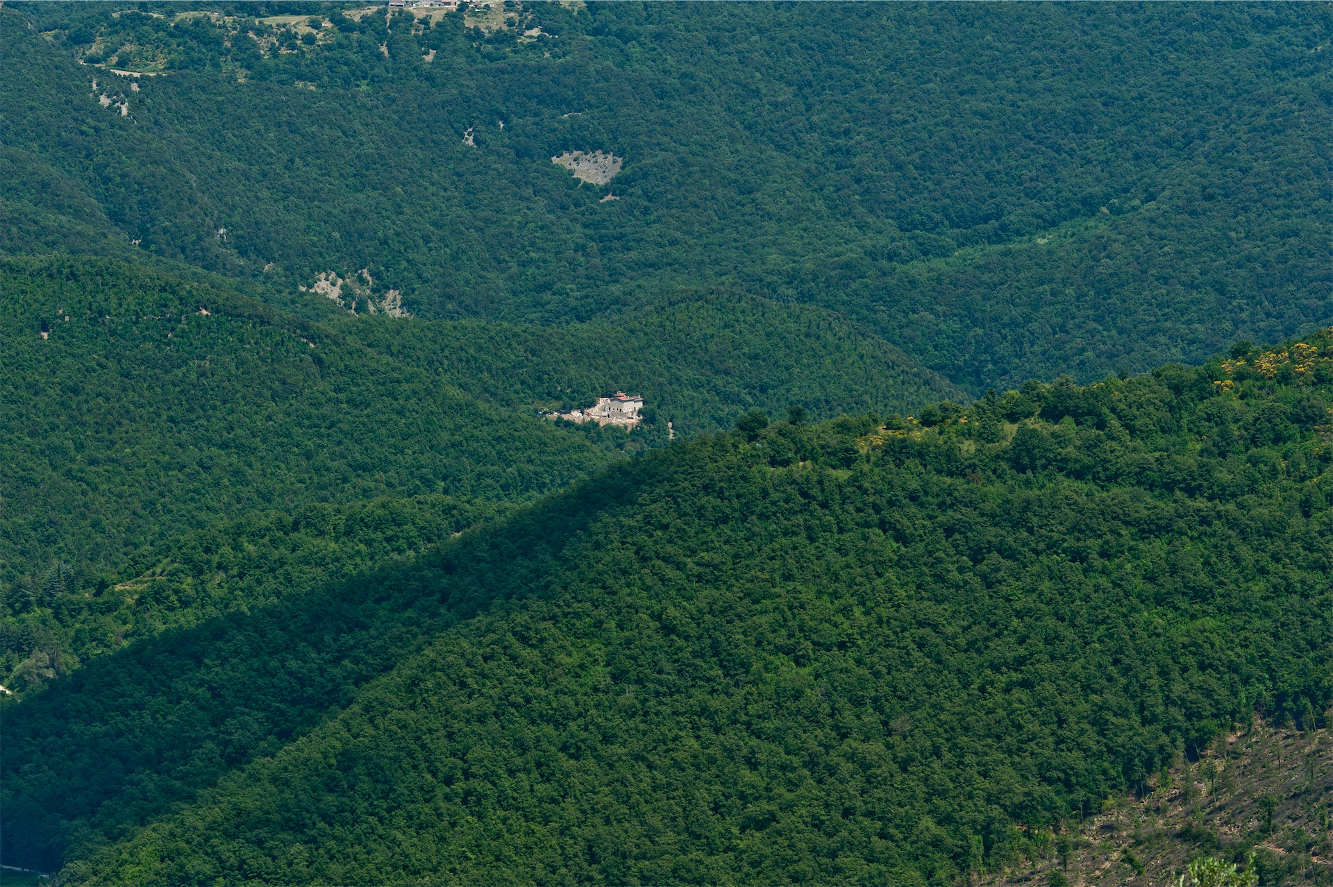 Aerial view of Eremito nestled within dense green forested hills.