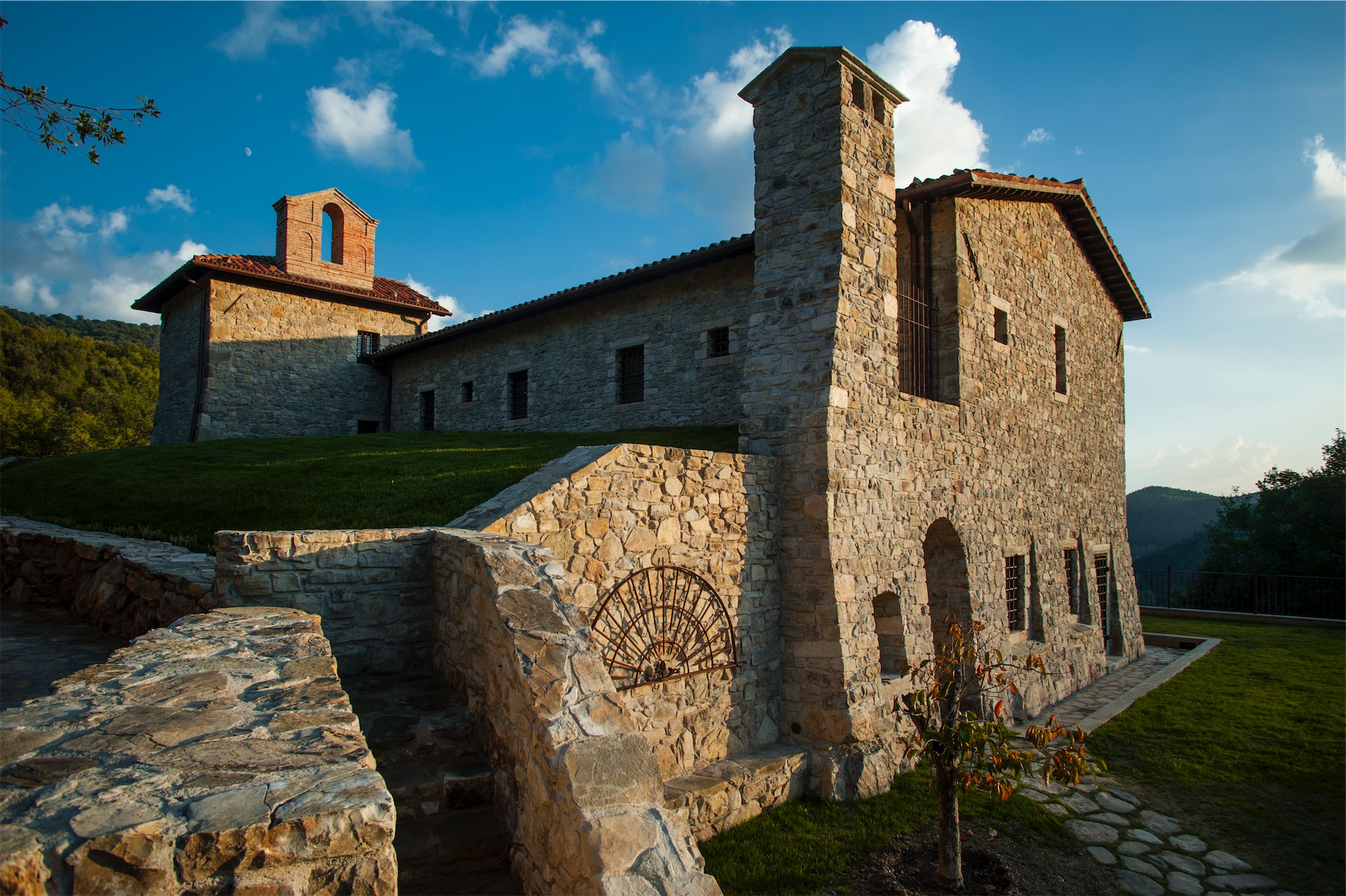 Stone exterior of Eremito set against the hillside under a blue sky.