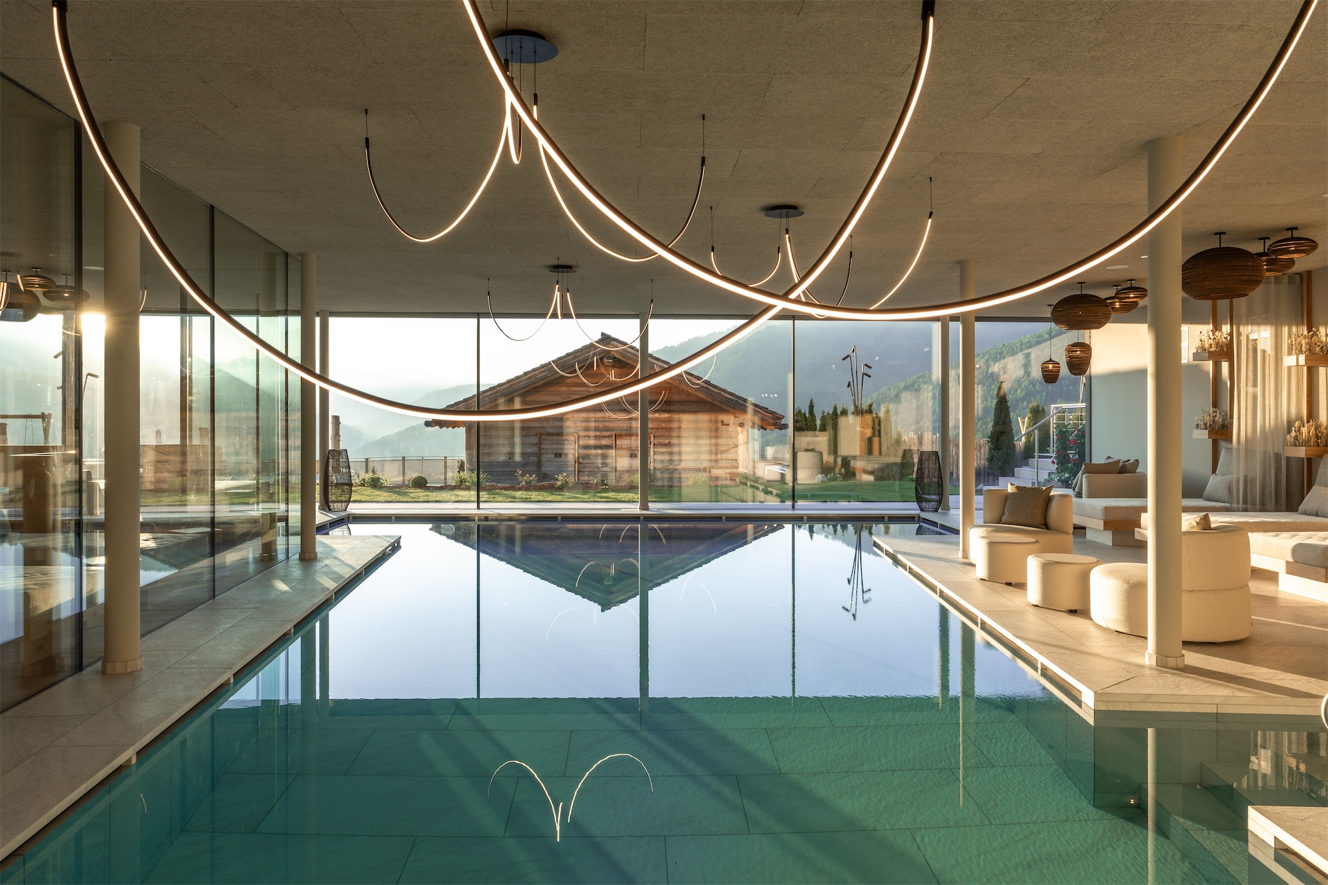 Indoor pool with panoramic mountain views at Hotel Hubertus.