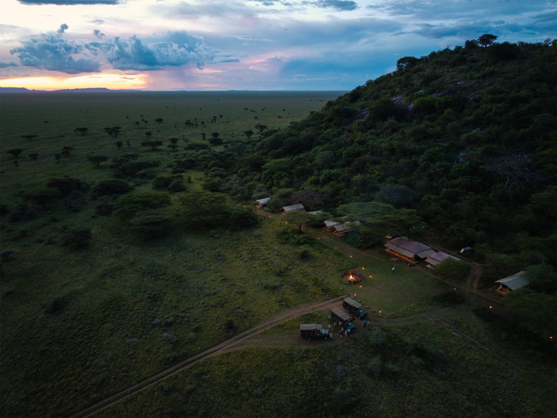 Aerial view of Esirai Camp overlooking a vast savannah landscape at sunset.