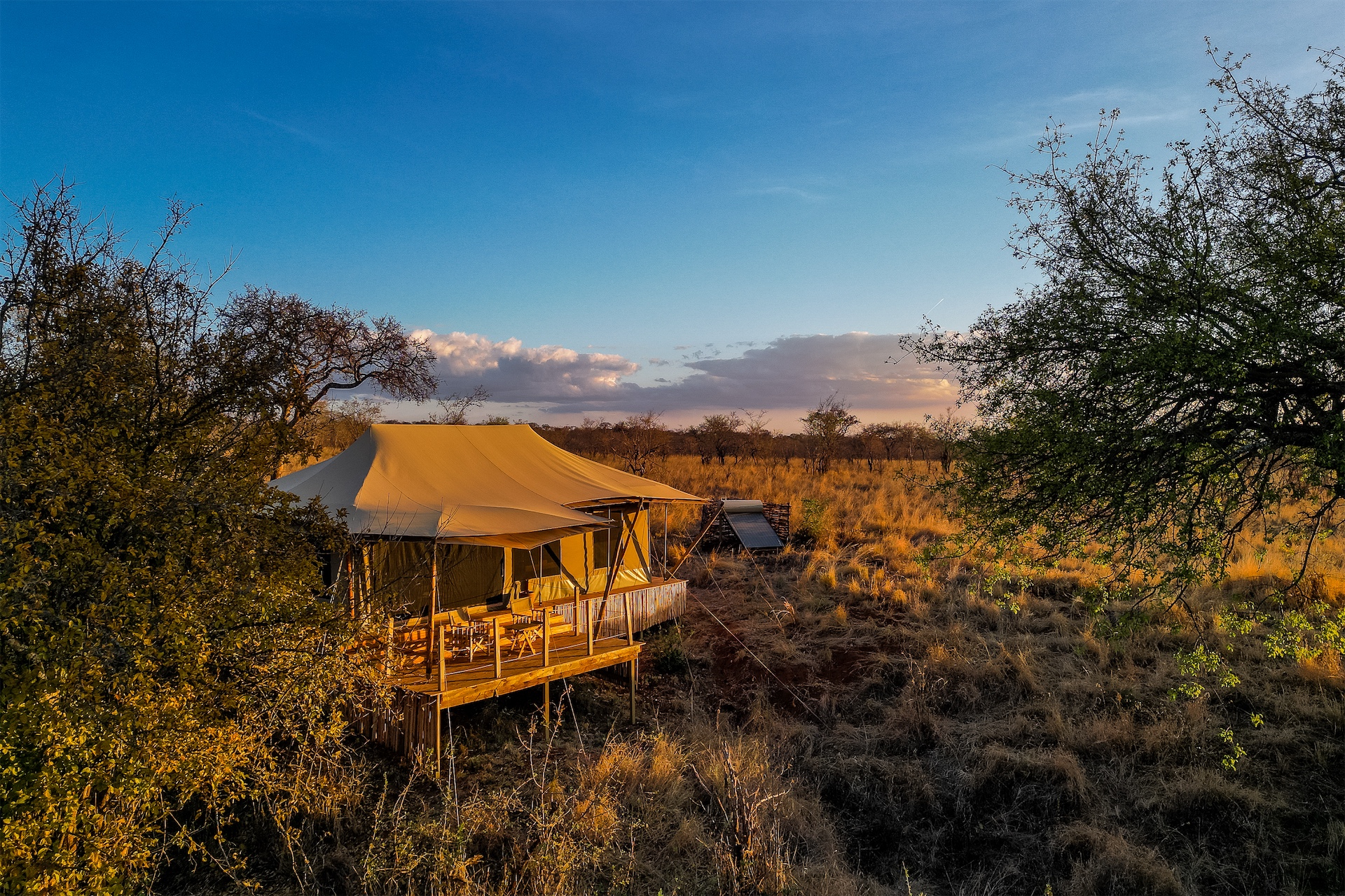 Raised safari tent overlooking the savannah at sunset at Olkeri Camp.