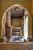 Suite interior with arched entry, brick detail, and lantern lighting at Anayela.