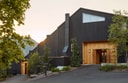Exterior entrance of Scribner’s Catskill Lodge with black timber facade and warm wood detailing at sunset.