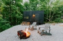 Postcard cabin with outdoor firepit chairs and forest setting