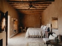 Superior Ayurt bedroom at Berber Lodge with twin beds, earthen walls, and a central seating area.