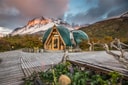 Superior Dome glowing at sunset beneath snow-covered mountains at Ecocamp Patagonia.