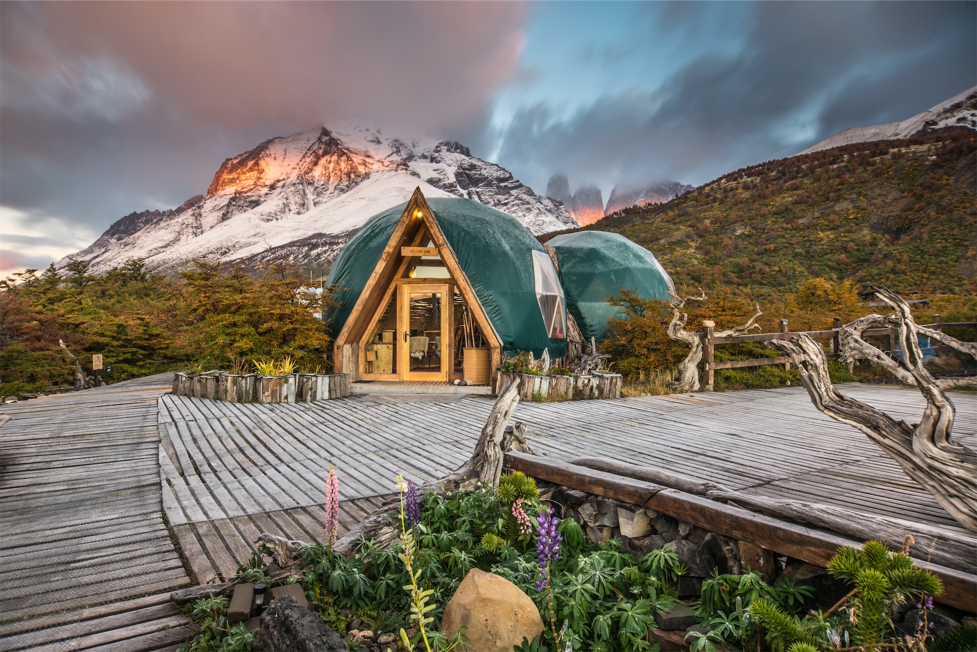 Superior Dome glowing at sunset beneath snow-covered mountains at Ecocamp Patagonia.