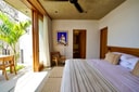 Bedroom interior at El Guayacán with natural materials and terrace access.