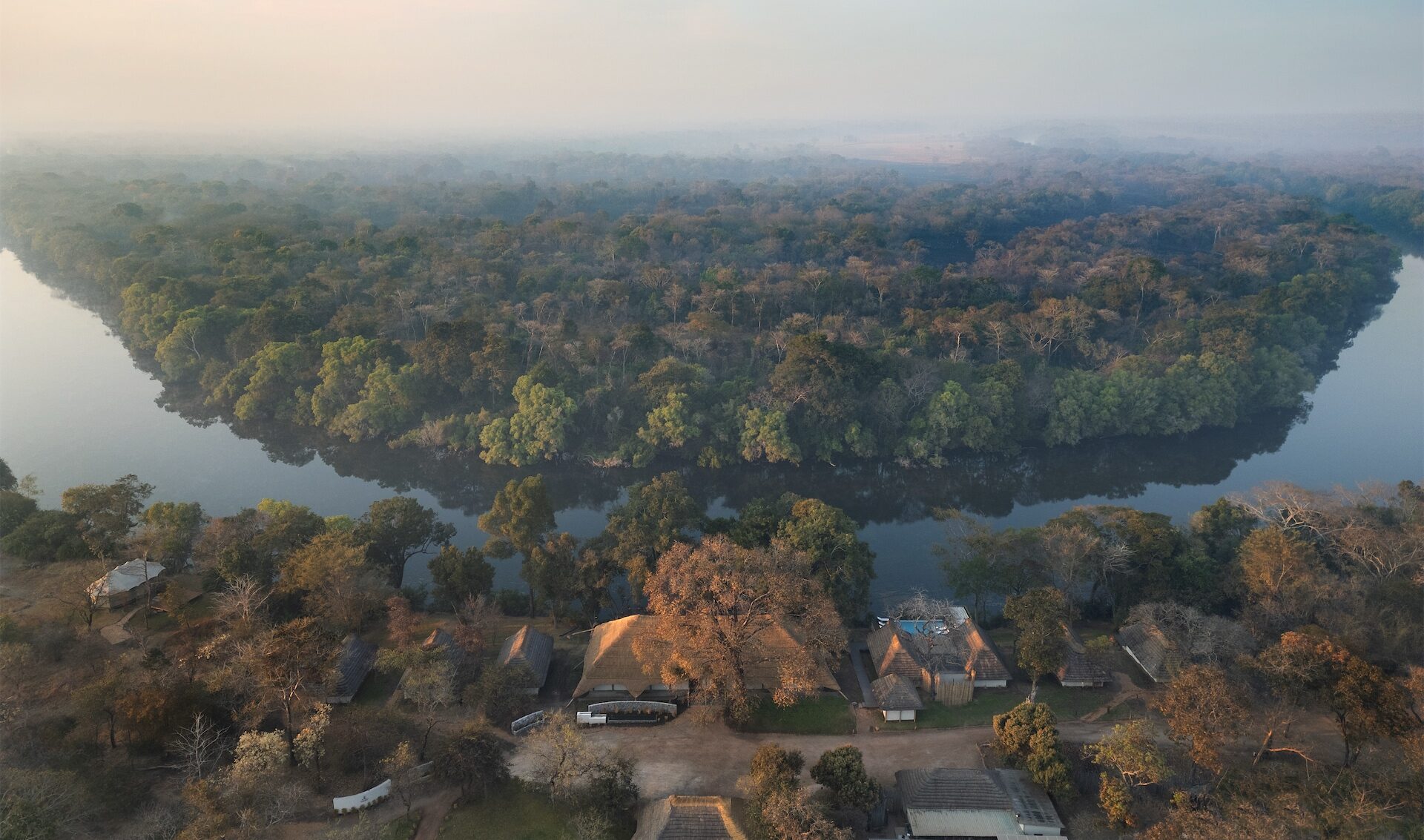 An aerial view of dense forest surrounded by a winding river at Lolelunga Private Reserve.