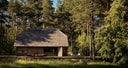 Exterior view of timber cabin surrounded by pine forest at Vipp Salaca River.