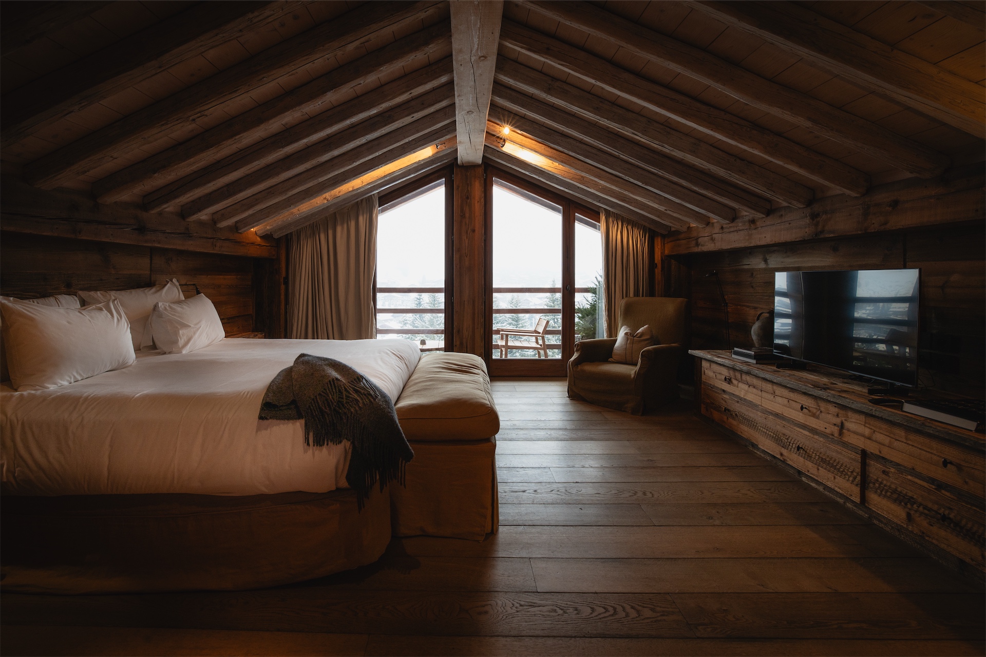 Luxury alpine bedroom with balcony and mountain views at Zannier Le Chalet.