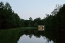 Vipp Pavilion reflected in a quiet pond surrounded by forest in Upstate New York